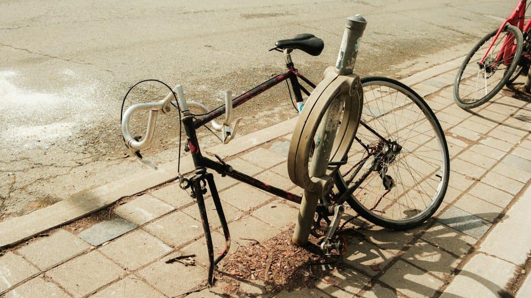 Bicicleta atada a un poste en la acera